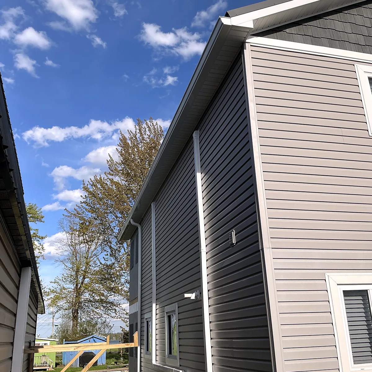 Gable and siding installation viewed from the side near a waterfront setting.